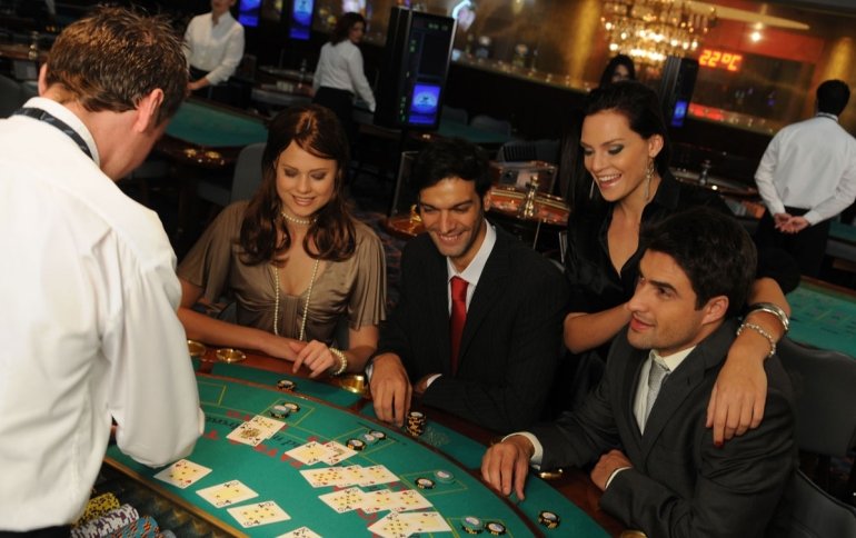 Двое богатых мужчин восточной внешности играют в блэкджек в компании красивых девушек в престижном казино Шарм-эль-Шейха
