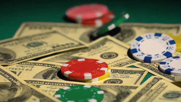 Фишки для покера разложенные на стодолларовых купюрах