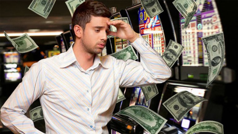 парень возле игровых автоматов среди летающих долларов